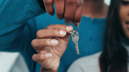 A pair of hands holding a house key.